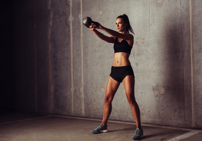 Brunette sportswoman working out her arms with a kettlebell