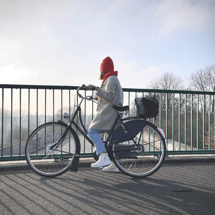 Frau fährt mit Fahrrad über eine Brücke